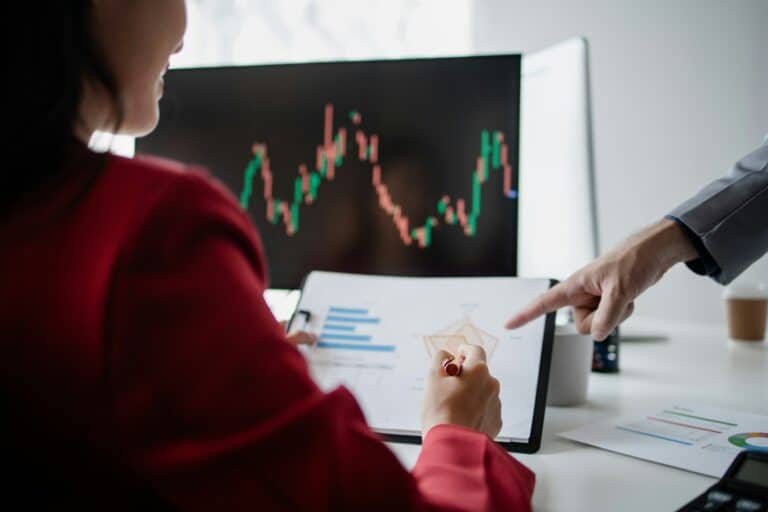 Two investors look at stock insights to analyze risk, stock investing businessman analyzing stock ma
